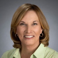 A woman with blonde hair and wearing a green shirt.